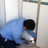 The installer works on a reach-in closet